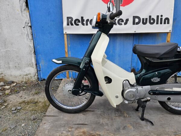 Close-up of the front fender, leg shield, and front wheel of the Honda Super Cub C50.